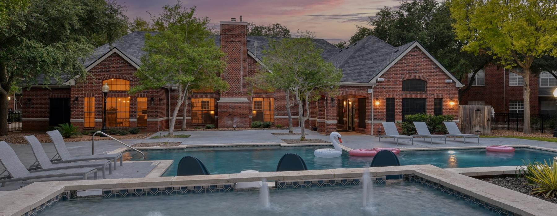 a swimming pool in front of an apartment leasing office