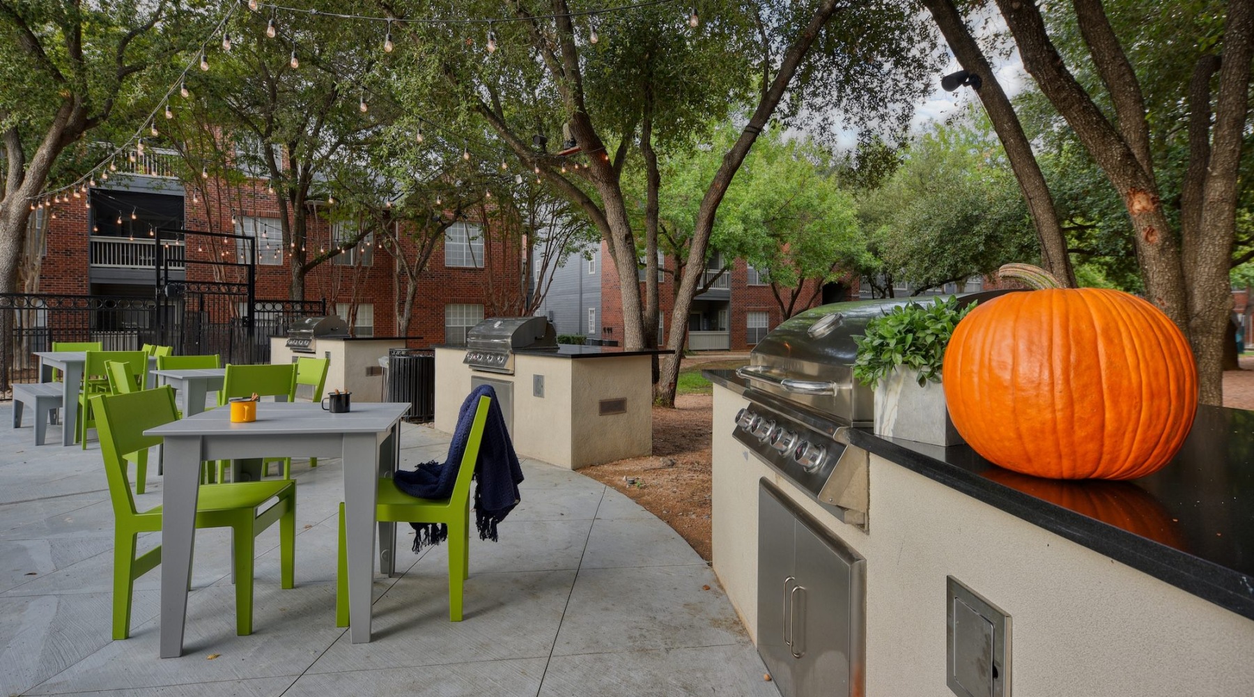 a grilling area with seating and tables
