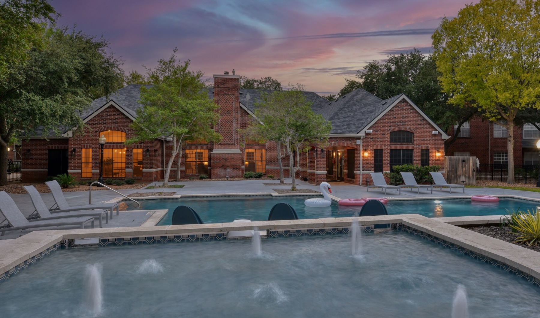 a pool area in front of a building at dusk